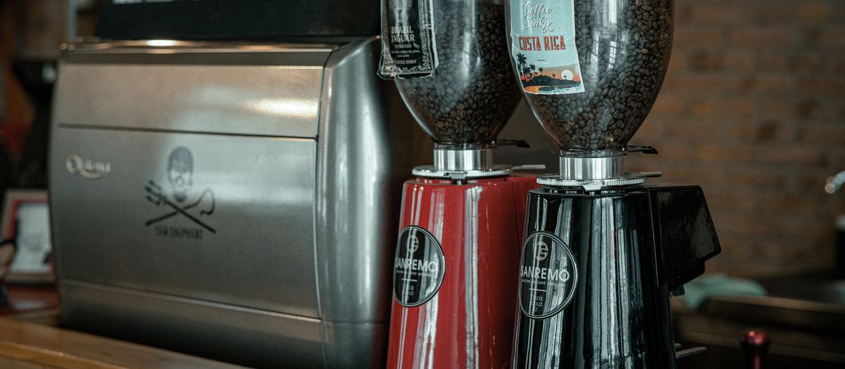 An espresso machine and a coffee grinder side by side on a kitchen counter.