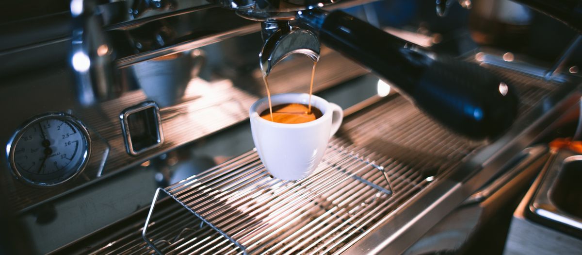 An espresso machine pressure gauge and group head.